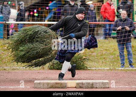 Weidenthal, Deutschland. Januar 2024. Ein Teilnehmer schleudert eine Fichte bei der 16. Weihnachtsbaumwurfweltmeisterschaft. Die vom FC Wacker Weidenthal gegründete „Weltmeisterschaft“ findet in einem drei-Wege-Wettbewerb statt: Langwurf, Hochwurf und Schleudern eines etwa 1,50 Meter großen Baumes. Quelle: Uwe Anspach/dpa/Alamy Live News Stockfoto