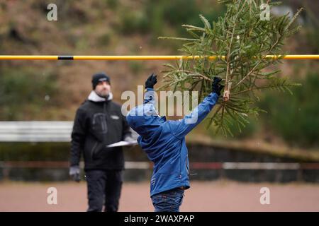 Weidenthal, Deutschland. Januar 2024. Ein junger Teilnehmer wirft eine Fichte bei der 16. Weihnachtsbaumweltmeisterschaft. Die vom FC Wacker Weidenthal gegründete „Weltmeisterschaft“ findet in einem drei-Wege-Wettbewerb statt: Langwurf, Hochwurf und Schleudern eines Baumes von etwa 1,50 Metern. Quelle: Uwe Anspach/dpa/Alamy Live News Stockfoto