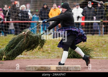 Weidenthal, Deutschland. Januar 2024. Ein Teilnehmer schleudert eine Fichte bei der 16. Weihnachtsbaumwurfweltmeisterschaft. Die vom FC Wacker Weidenthal gegründete „Weltmeisterschaft“ findet in einem drei-Wege-Wettbewerb statt: Langwurf, Hochwurf und Schleudern eines etwa 1,50 Meter großen Baumes. Quelle: Uwe Anspach/dpa/Alamy Live News Stockfoto