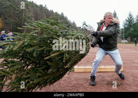 Weidenthal, Deutschland. Januar 2024. Ein Teilnehmer schleudert eine Fichte bei der 16. Weihnachtsbaumwurfweltmeisterschaft. Die vom FC Wacker Weidenthal gegründete „Weltmeisterschaft“ findet in einem drei-Wege-Wettbewerb statt: Langwurf, Hochwurf und Schleudern eines etwa 1,50 Meter großen Baumes. Quelle: Uwe Anspach/dpa/Alamy Live News Stockfoto