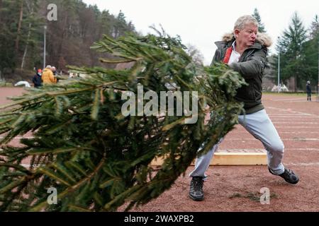 Weidenthal, Deutschland. Januar 2024. Ein Teilnehmer schleudert eine Fichte bei der 16. Weihnachtsbaumwurfweltmeisterschaft. Die vom FC Wacker Weidenthal gegründete „Weltmeisterschaft“ findet in einem drei-Wege-Wettbewerb statt: Langwurf, Hochwurf und Schleudern eines etwa 1,50 Meter großen Baumes. Quelle: Uwe Anspach/dpa/Alamy Live News Stockfoto