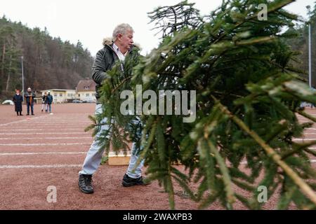 Weidenthal, Deutschland. Januar 2024. Ein Teilnehmer schleudert eine Fichte bei der 16. Weihnachtsbaumwurfweltmeisterschaft. Die vom FC Wacker Weidenthal gegründete „Weltmeisterschaft“ findet in einem drei-Wege-Wettbewerb statt: Langwurf, Hochwurf und Schleudern eines etwa 1,50 Meter großen Baumes. Quelle: Uwe Anspach/dpa/Alamy Live News Stockfoto