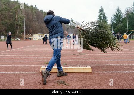 Weidenthal, Deutschland. Januar 2024. Ein Teilnehmer schleudert eine Fichte bei der 16. Weihnachtsbaumwurfweltmeisterschaft. Die vom FC Wacker Weidenthal gegründete „Weltmeisterschaft“ findet in einem drei-Wege-Wettbewerb statt: Langwurf, Hochwurf und Schleudern eines etwa 1,50 Meter großen Baumes. Quelle: Uwe Anspach/dpa/Alamy Live News Stockfoto