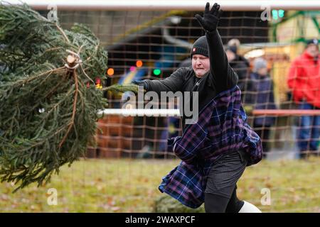 Weidenthal, Deutschland. Januar 2024. Ein Teilnehmer schleudert eine Fichte bei der 16. Weihnachtsbaumwurfweltmeisterschaft. Die vom FC Wacker Weidenthal gegründete „Weltmeisterschaft“ findet in einem drei-Wege-Wettbewerb statt: Langwurf, Hochwurf und Schleudern eines etwa 1,50 Meter großen Baumes. Quelle: Uwe Anspach/dpa/Alamy Live News Stockfoto