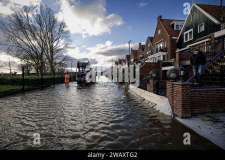 VOLENDAM – Ein Bauunternehmen, das von der Gemeinde beauftragt wurde, pumpt Wasser aus einer Straße in Volendam. An verschiedenen Stellen rund um das Markermeer wurden Sandsäcke platziert, um die Deiche zu verstärken und so die Häuser vor dem sehr hohen Wasserstand zu schützen, der vom Wind hochgeschoben wird. ANP ROBIN VAN LONKHUIJSEN niederlande aus - belgien aus Stockfoto