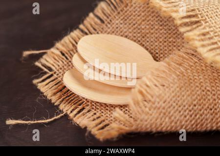 Holzlöffel Set aus Bambus umweltfreundlichem Material mit rustikalem Sacktuch auf braunem Tisch Stockfoto