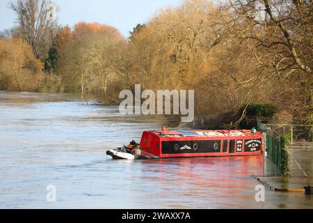 Wallingford, Vereinigtes Königreich, 7. Januar 2024. Wetter in Großbritannien - die starken Regenfälle in den letzten Tagen führten zu weit verbreiteten Überschwemmungen im Themental bei Wallingford. Ein schmales Boot, das im Fluss schwimmt. Quelle: Uwe Deffner/Alamy Live News Stockfoto