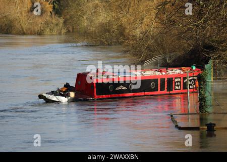 Wallingford, Vereinigtes Königreich, 7. Januar 2024. Wetter in Großbritannien - die starken Regenfälle in den letzten Tagen führten zu weit verbreiteten Überschwemmungen im Themental bei Wallingford. Ein schmales Boot, das im Fluss schwimmt. Quelle: Uwe Deffner/Alamy Live News Stockfoto