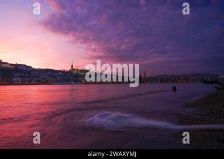 Budapest, Ungarn - 29. Dezember 2023: Wunderschöner Sonnenuntergang. Überflutete Donau im Vordergrund. Fisherman Bastion im Hintergrund. Stockfoto