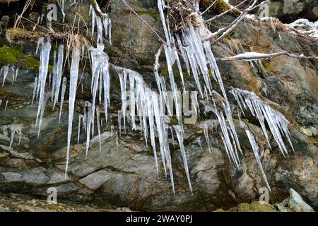 Eiszapfen hängen vom Felsen Stockfoto