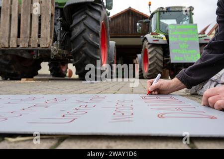 07. Januar 2024, Bayern, Wüstenwelsberg: Ein Mann schreibt ein Protestzeichen für einen Schlepper. Die Landwirte bereiten sich auf die kommende Aktionswoche vor. Tausende von Landwirten wollen gegen die Agrarpolitik demonstrieren. Foto: Pia Bayer/dpa Stockfoto