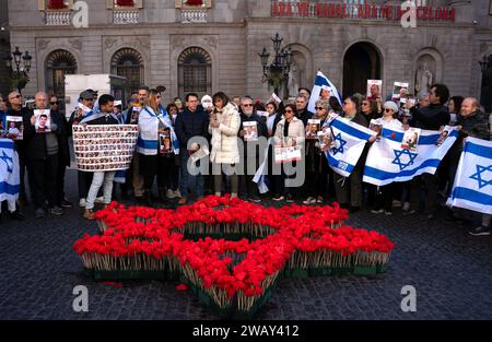 Barcelona, Spanien. Januar 2024. Eine Gruppe von Juden steht vor einem Davidstern, der mit roten Blumen erschaffen wurde, um an den dritten Monat der Entführung israelischer Zivilisten durch die Hamas-Gruppe zu erinnern und den Ermordeten bei der Demonstration zu ehren. Rund 50 Menschen aus Barcelonas jüdischer Gemeinde versammelten sich auf dem Plac Sant Jaume, um den dritten Monat der Entführung israelischer Zivilisten durch die Hamas zu feiern. (Foto: Ximena Borrazas/SOPA Images/SIPA USA) Credit: SIPA USA/Alamy Live News Stockfoto