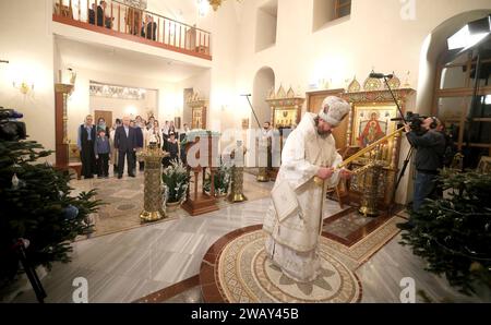 Novo-Ogaryovo, Russland. Januar 2024. Der russisch-orthodoxe Erzbischof Nikolaj Mosolov, rechts, führt eine Weihnachtsmesse, während Präsident Wladimir Putin am 7. Januar 2024 in Nowo-Ogarjowo, Oblast Moskau, Russland, an der Kirche des Erlösers teilnimmt. Putin beherbergte Familien von Soldaten, die im Ukraine-Krieg getötet wurden. Quelle: Gavriil Grigorov/Kreml Pool/Alamy Live News Stockfoto