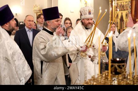 Novo-Ogaryovo, Russland. Januar 2024. Der russisch-orthodoxe Erzbischof Nikolai Mosolov zündet Kerzen während einer Weihnachtsmesse mit Präsident Wladimir Putin in der Kirche der Ikone des Erlösers nicht von Händen in der offiziellen Residenz des Präsidenten am 7. Januar 2024 in Novo-Ogarjowo, Oblast Moskau, Russland. Putin beherbergte Familien von Soldaten, die im Ukraine-Krieg getötet wurden. Quelle: Gavriil Grigorov/Kreml Pool/Alamy Live News Stockfoto