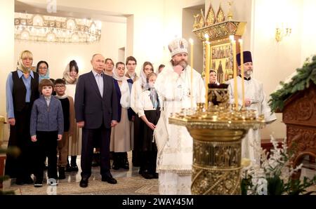 Novo-Ogaryovo, Russland. Januar 2024. Der russisch-orthodoxe Erzbischof Nikolaj Mosolov, rechts, führt eine Weihnachtsmesse, während Präsident Wladimir Putin am 7. Januar 2024 in Nowo-Ogarjowo, Oblast Moskau, Russland, an der Kirche des Erlösers teilnimmt. Putin beherbergte Familien von Soldaten, die im Ukraine-Krieg getötet wurden. Quelle: Gavriil Grigorov/Kreml Pool/Alamy Live News Stockfoto