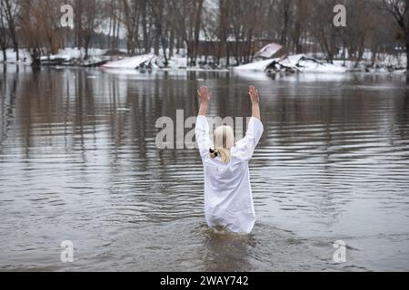 Kiew, Ukraine. Januar 2024. Eine Frau nimmt ein Bad im kalten Wasser des Flusses Dnipro anlässlich der Feier der Epiphanik in Kiew. Die Ukraine feiert in diesem Jahr erstmals die Epiphanik am 6. Januar nach dem westlichen Kalender und weicht von der Tradition der russisch-orthodoxen Kirche ab, sie am 19. Januar zu feiern. Während der Epiphanienzeit glauben manche, dass das Wasser besondere heilende Eigenschaften hat und zur Behandlung verschiedener Krankheiten verwendet werden kann, und viele von ihnen nehmen im Rahmen der Epiphanienfeier ein Bad im Wasser. (Credit Image: © Oleksii Chumachenko/SOPA Images via ZUMA Press Wire Stockfoto