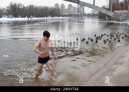 Kiew, Ukraine. Januar 2024. Ein Mann kommt aus dem Wasser, nachdem er im kalten Fluss Dnipro geschwommen ist, anlässlich der Feier der Epiphanik in Kiew. Die Ukraine feiert in diesem Jahr erstmals die Epiphanik am 6. Januar nach dem westlichen Kalender und weicht von der Tradition der russisch-orthodoxen Kirche ab, sie am 19. Januar zu feiern. Während der Epiphanienzeit glauben manche, dass das Wasser besondere heilende Eigenschaften hat und zur Behandlung verschiedener Krankheiten verwendet werden kann, und viele von ihnen nehmen im Rahmen der Epiphanienfeier ein Bad im Wasser. (Credit Image: © Oleksii Chumachenko/SOPA Images via Z Stockfoto