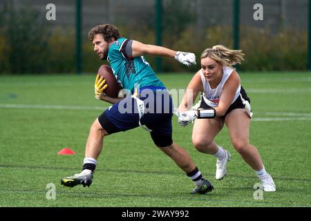 Coventry Cougars gegen Chichester Sharks Flag Football. Männlicher Spieler mit weiblichem Tagging Stockfoto