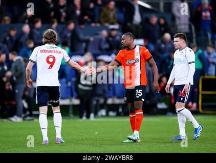 Bolton Wanderers' Jon Dadi Bodvarsson schüttelt am Ende des Spiels der dritten Runde des Emirates FA Cup in der Kenilworth Road, Luton, die Hand mit Teden Mengi von Luton Town. Bilddatum: Sonntag, 7. Januar 2024. Stockfoto