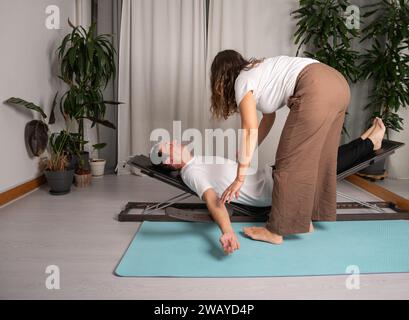 Entspannter Mann, der Yoga-Posen mit dem Lehrer lernt Stockfoto