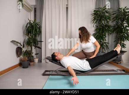 Entspannter Mann, der Yoga-Posen mit dem Lehrer lernt Stockfoto