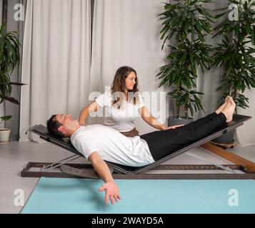 Entspannter Mann, der Yoga-Posen mit dem Lehrer lernt Stockfoto