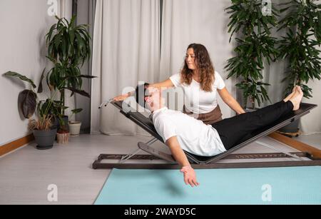 Entspannter Mann, der Yoga-Posen mit dem Lehrer lernt Stockfoto