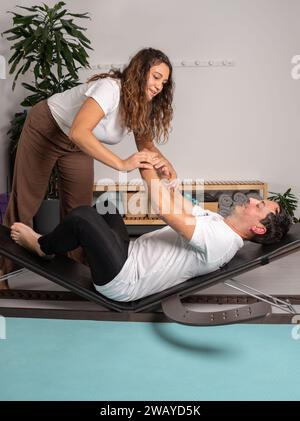 Entspannter Mann, der Yoga-Posen mit dem Lehrer lernt Stockfoto