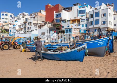 Kleine, blaue, hölzerne Fischerboote am Strand in Taghazout, Marokko, Nordafrika Stockfoto