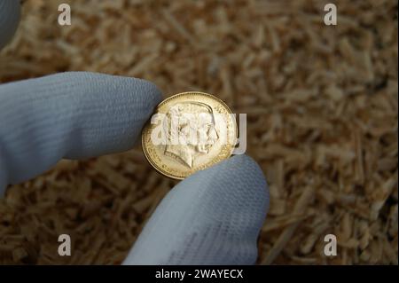 20 Kronen Christian X 1917. Eine alte dänische Goldmünze in den Händen eines Numismatikers. Stockfoto