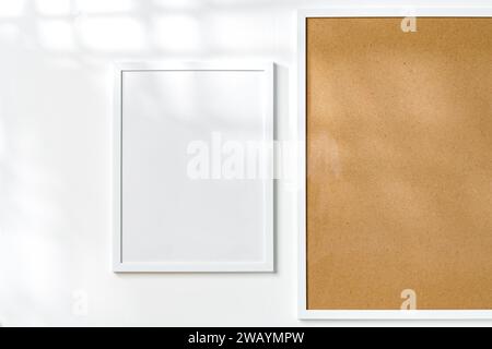 Korkbrett und leerer Rahmen hängen an der Wand Stockfoto