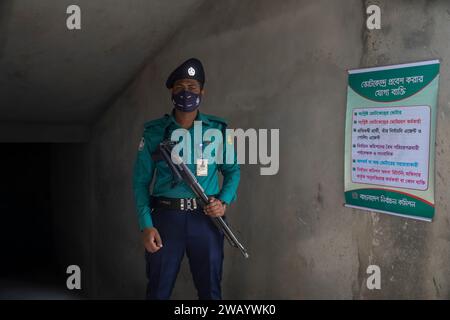 Dhaka, Bangladesch. Januar 2024. Ein Polizeibeamter aus Bangladesch steht während der 12. Nationalparlamentarwahlen in Bangladesch an einer Polstation auf Wache. Quelle: SOPA Images Limited/Alamy Live News Stockfoto