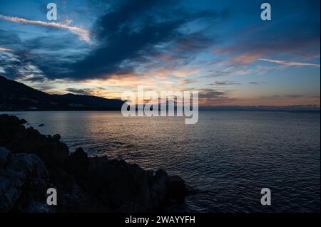 Sonnenuntergang von den Docks über dem Meer und den Bergen des Dorfes Cefalu, Sizilien, Italien Stockfoto