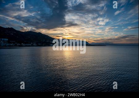 Sonnenuntergang von den Docks über dem Meer und den Bergen des Dorfes Cefalu, Sizilien, Italien Stockfoto