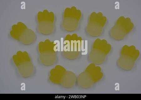 Gebrandete, werkseitig gefertigte gummiartige Kinderbonbons in Form von kleinen Früchten, Ananas auf weißem Kunststoffhintergrund. Stockfoto