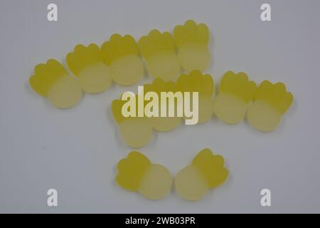 Gebrandete, werkseitig gefertigte gummiartige Kinderbonbons in Form von kleinen Früchten, Ananas auf weißem Kunststoffhintergrund. Stockfoto