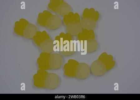 Gebrandete, werkseitig gefertigte gummiartige Kinderbonbons in Form von kleinen Früchten, Ananas auf weißem Kunststoffhintergrund. Stockfoto