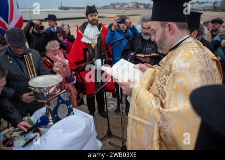 Der Priester liest die Bibel den Gläubigen in Griechisch während der Zeremonie vor. Die zyprische Diaspora organisierte Seegung, ein jährliches griechisch-orthodoxes religiöses Ereignis der Erleuchtung. Stockfoto