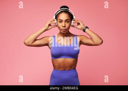 Athletische afroamerikanische Sportlerin im Fitnessstudio mit Kopfhörern, Studio Stockfoto