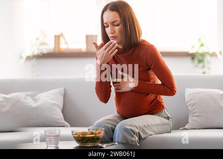 Schwangere Frau, Die An Toxikose Leidet, Mit Übelkeit Während Des Mittagessens In Innenräumen Stockfoto