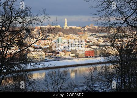 Der späte Blick auf Kaunas Innenstadt am Fluss Neman und die moderne Christus-Auferstehungsbasilika auf einem Hügel während des Winters (Litauen). Stockfoto