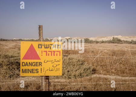 Das Schild „Danger Mines!“ (In Englisch, Arabisch und Hebräisch) vor dem großen Minenfeld im Westjordanland, palästinensische Gebiete/Palästina. Stockfoto