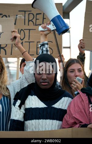 Ernsthafte muslimische Frau mitten in einer Demonstration einer Gruppe von Aktivisten Stockfoto