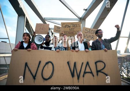 Menschen aus verschiedenen Rassen, die gegen Krieg und Gewalt in der Welt protestieren. Gruppe von Aktivisten Stockfoto