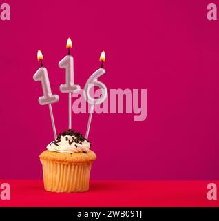 Kerze Nummer 116 - Kuchen Geburtstag in rhodaminrotem Hintergrund Stockfoto