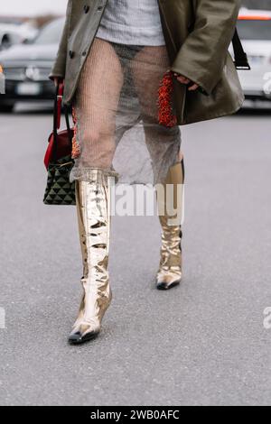 Mailand, Italien - 23. Februar 2023: Frau mit Prada-Symbol-Jacquard-Tragetasche, roter Cleo-Tasche und kniehohen Stiefeln aus gespiegeltem Leder. Mode-Blogger oder Stockfoto