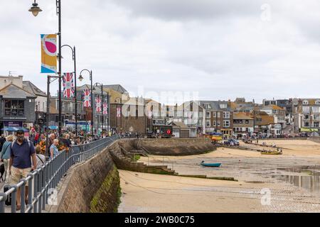 Im Stadtzentrum von St Ives Cornwall und bei Ebbe am Hafenstrand feiern Union Jack Banner die Krönung von König Charles, England, Großbritannien, Herbst 2023 Stockfoto