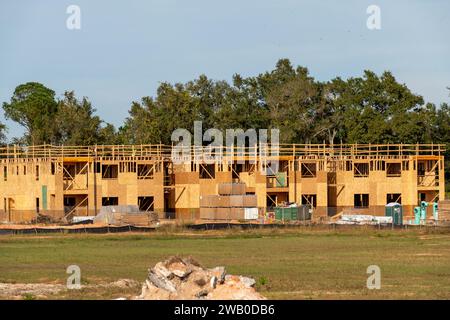 Ein großes dreistöckiges Holzwohnhaus oder Appartementgebäude befindet sich im Bau. Die neue Holzwerkstruktur ist in der Rahmen- und Schalung enthalten. Stockfoto