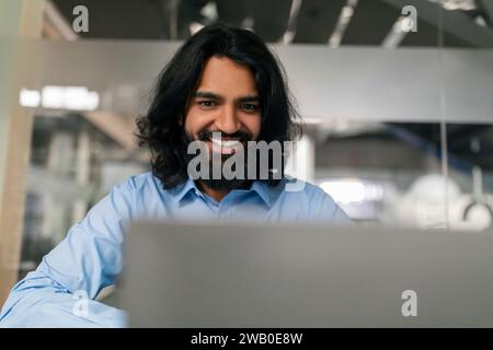 Nahaufnahme Des Lächelnden Jungen Indischen Bärtigen Mannes, Der An Laptop Arbeitet Stockfoto