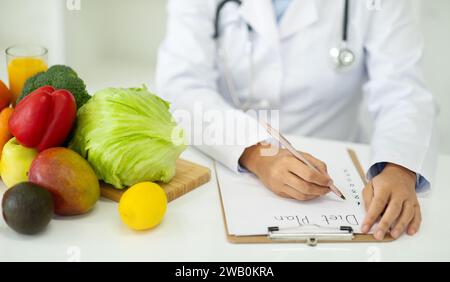 Abgeschnitten von Ernährungsberaterin, die an Diätplänen arbeitet. Stockfoto